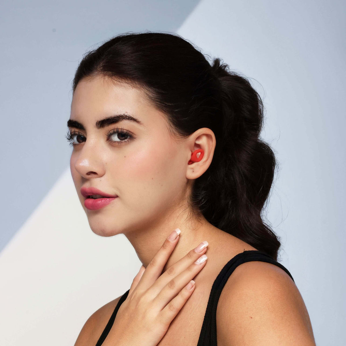 Model showcasing ZENZ Unwind Pro Earplugs in Fiery Red, ideal noise reduction earplugs for sleep.