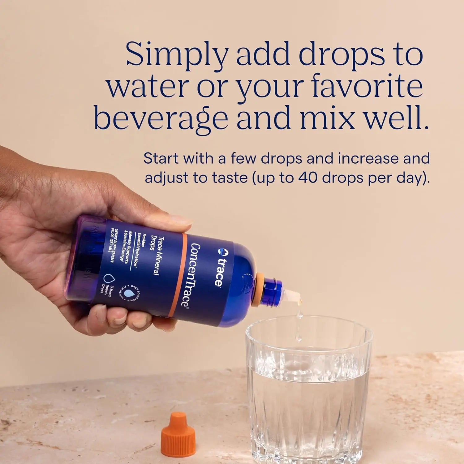 Person adding ConcenTrace trace mineral drops for hydration to a glass of water for enhanced flavor and hydration support.