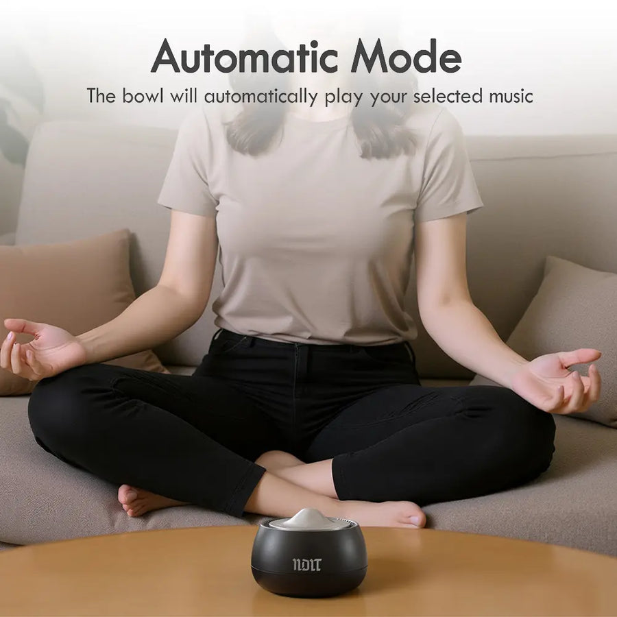 Woman meditating with a portable electronic Tibetan singing bowl for meditation in automatic mode.