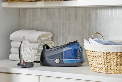 Rowenta Perfect Steam Pro, a professional garment steamer, on a counter next to neatly stacked towels.