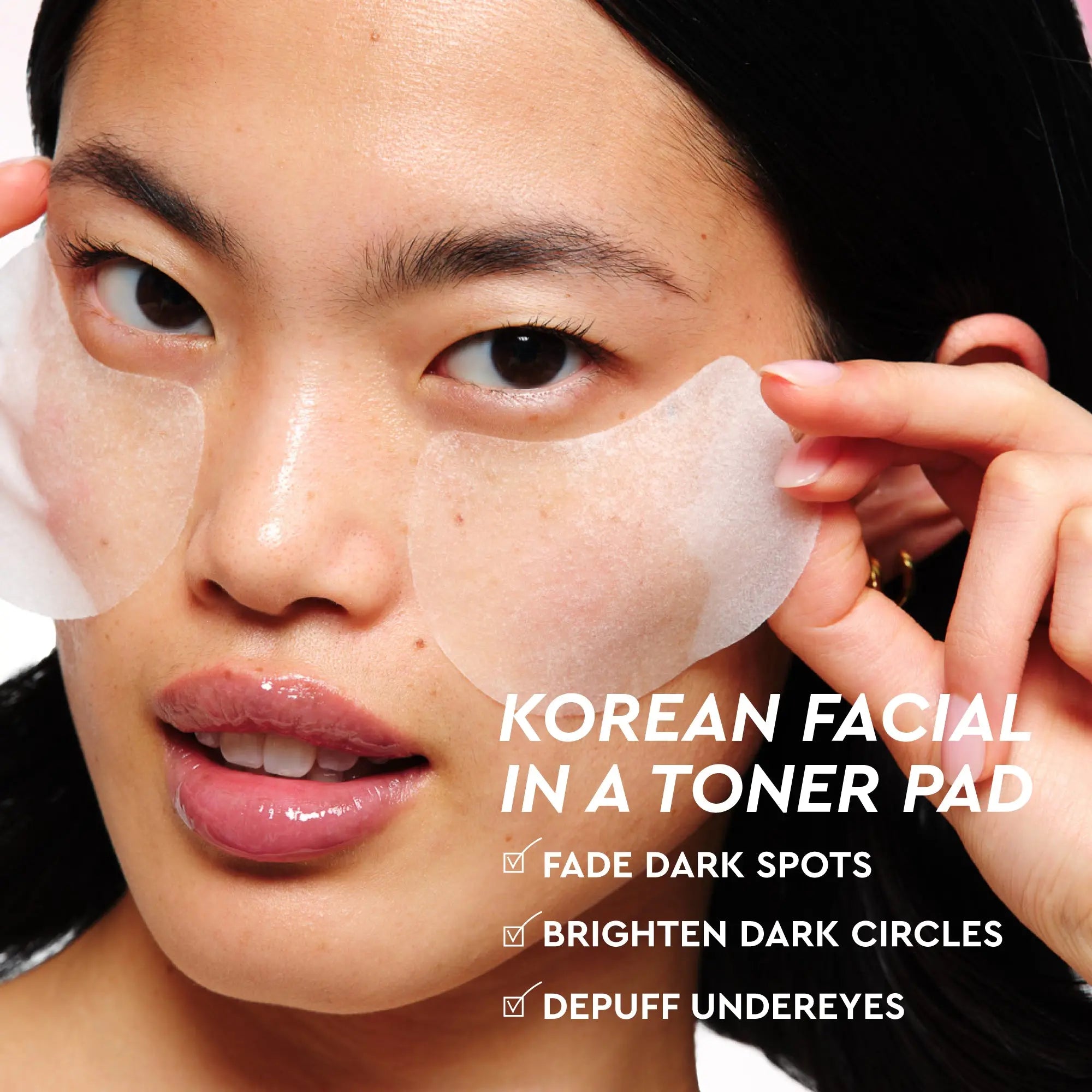 Korean vitamin C toner pads on a woman’s face, helping to fade dark spots, brighten dark circles, and depuff undereyes.